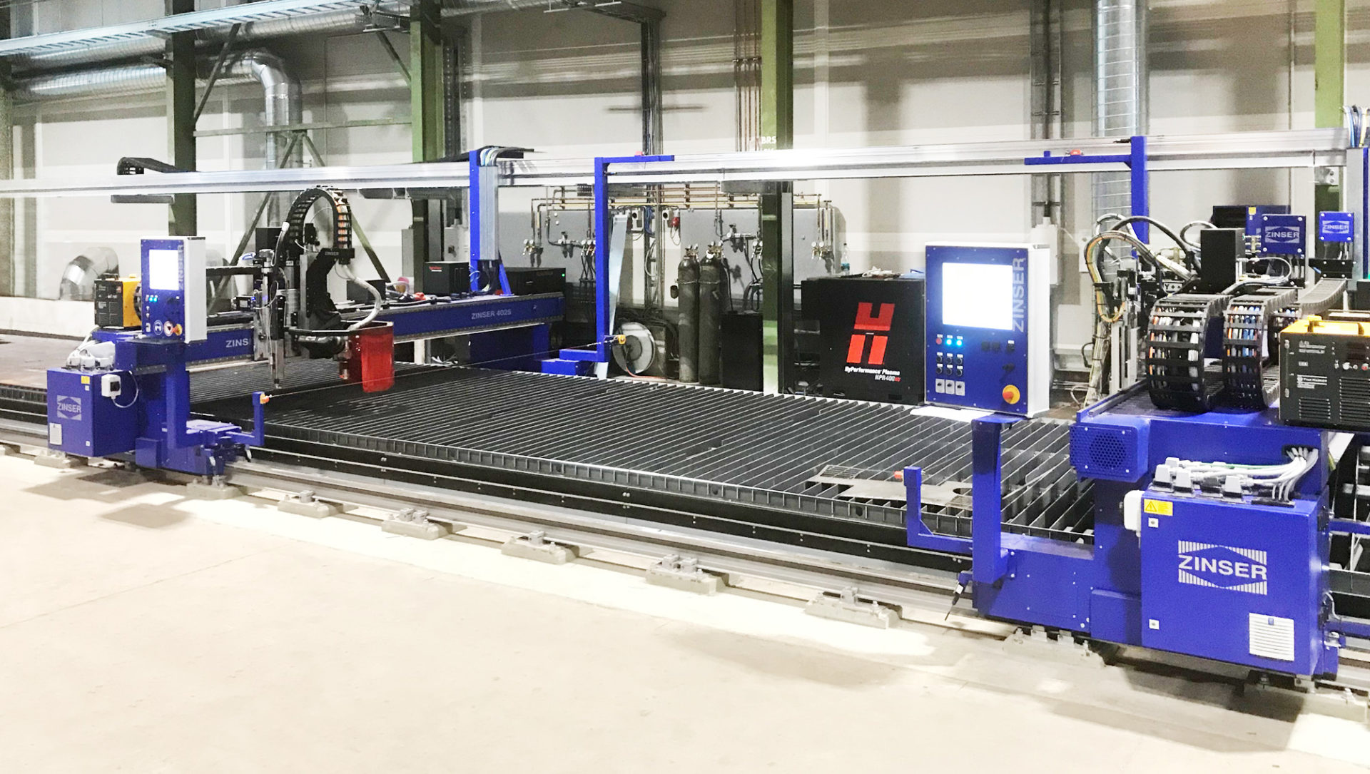 [:de] Zwei ZINSER Schneidmaschinen, ausgestattet mit einem Fasenaggregat, Autogen- und Plasmabrennern. [:en] Two ZINSER cutting machines equipped with a plasma bevel head, oxy-fuel and plasma torches